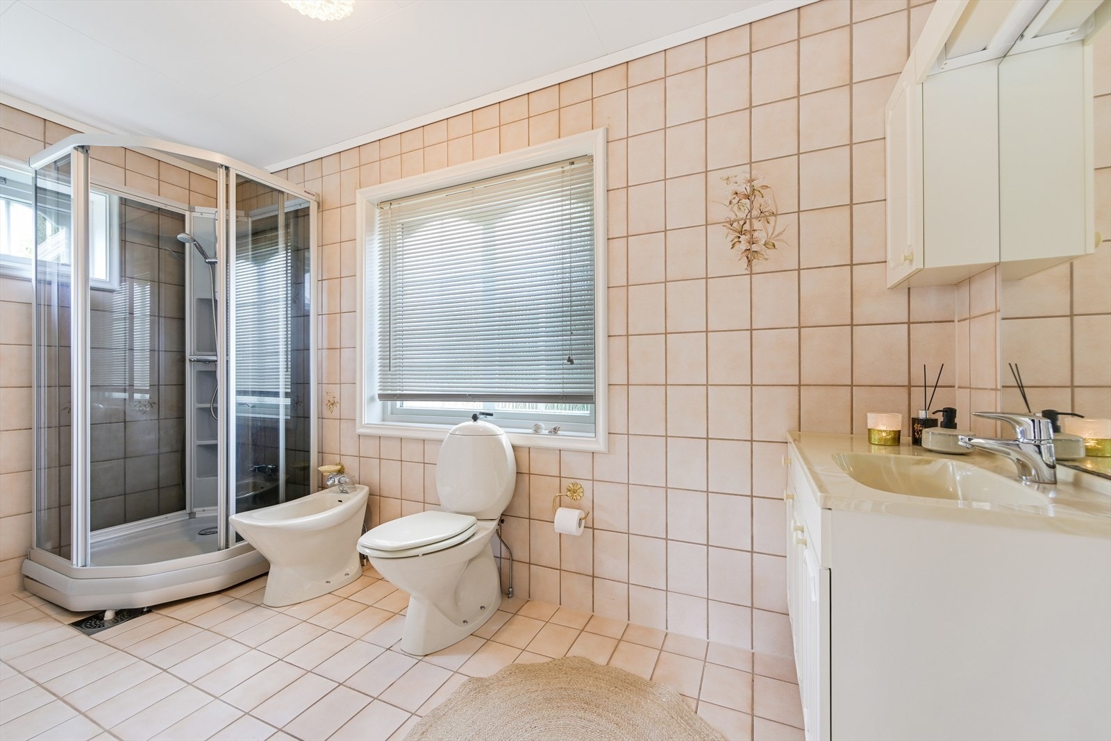 Fliselagt bad/wc i 1. etasje med dusjkabinett, wc, bidé, servant med underskap. Galleribilde