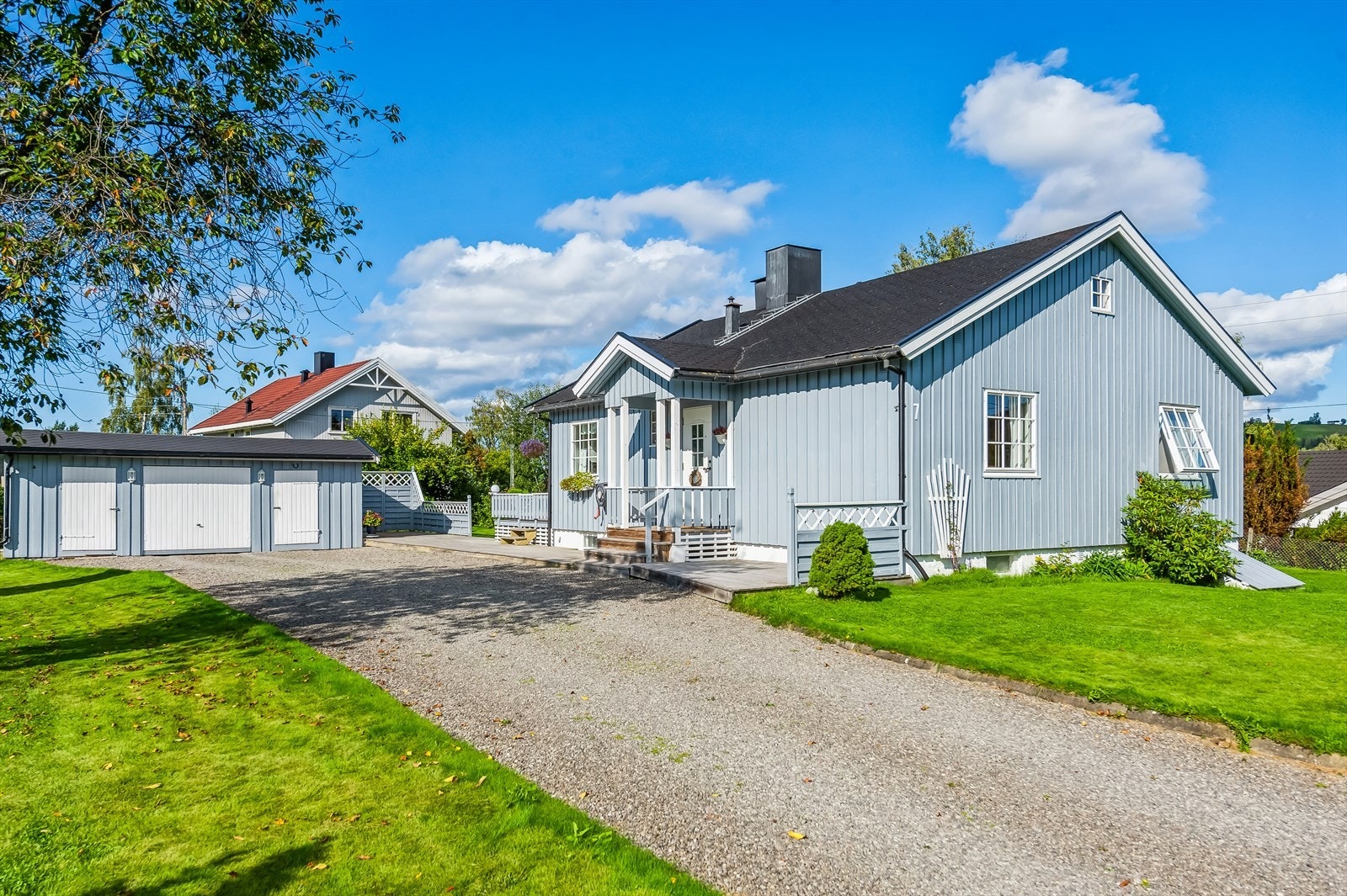 Gruset innkjørsel leder inn til garasje og boligen. Galleribilde