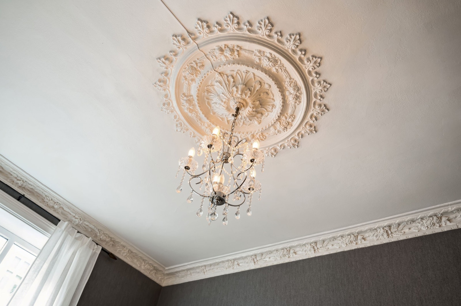 Stuen er utsmykket med original, flott stukkatur og rosett i tak. Galleribilde