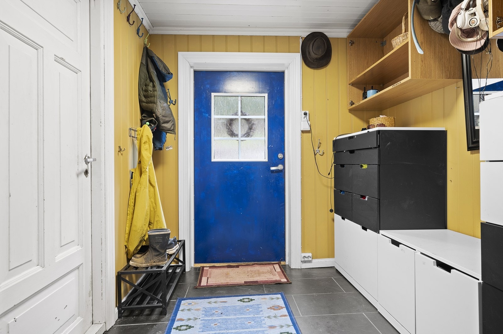 Fra et delvis overbygd inngangsparti kommer du inn i vindfanget. Herfra er det videre adkomst til bad/vaskerom, gang, 2 stuer og kjøkken. Galleribilde