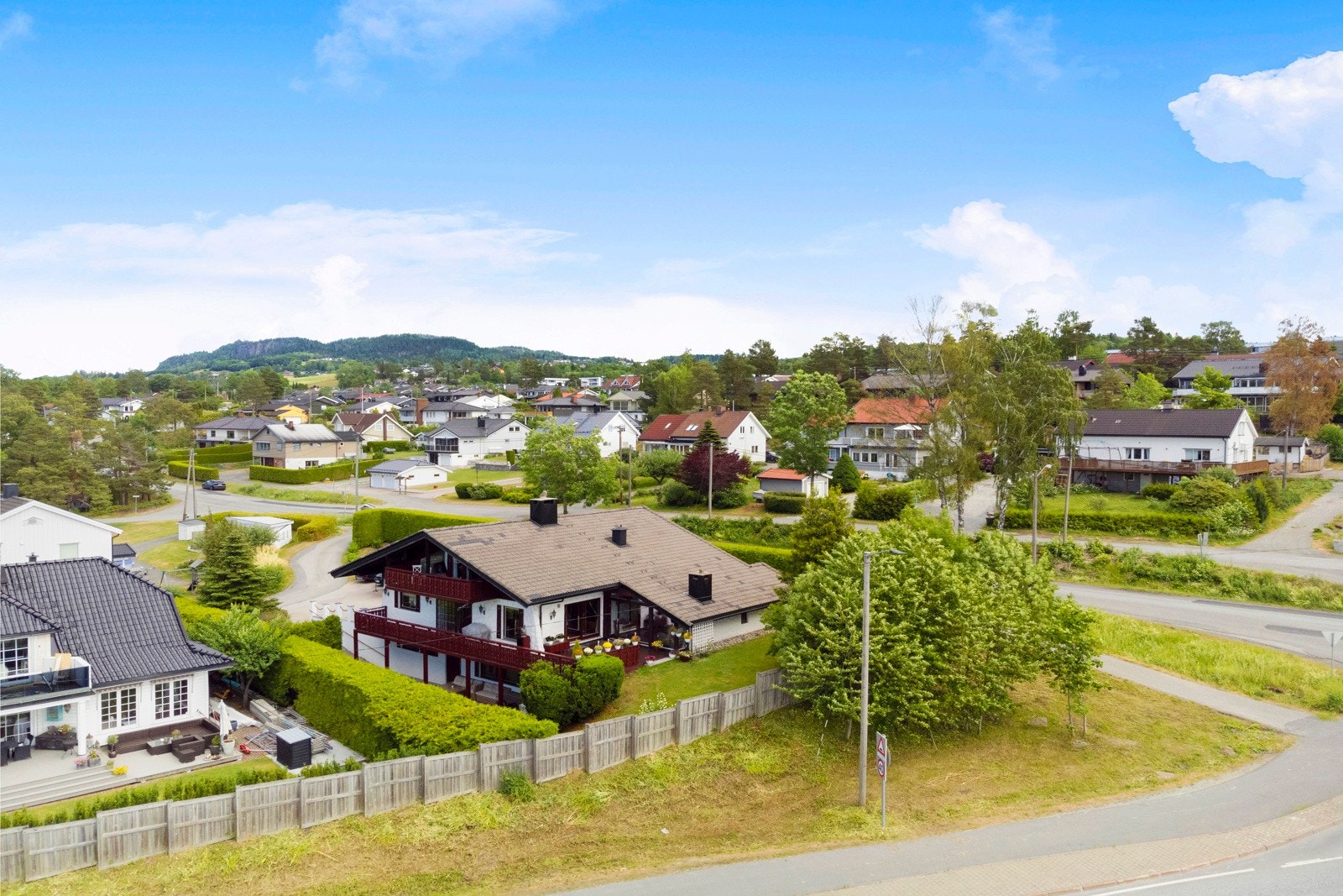 Mot veien er det både støyskjerm og beplantning. Hagen fremstår som svært usjenert. Galleribilde