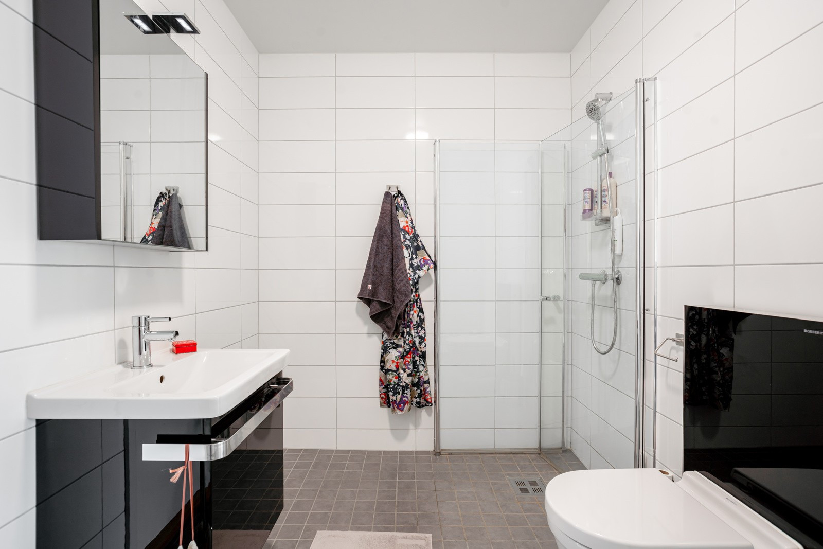 Badet er av fin størrelse med servantskap, speilskap, wc og dusj med innfellbare glassdører.