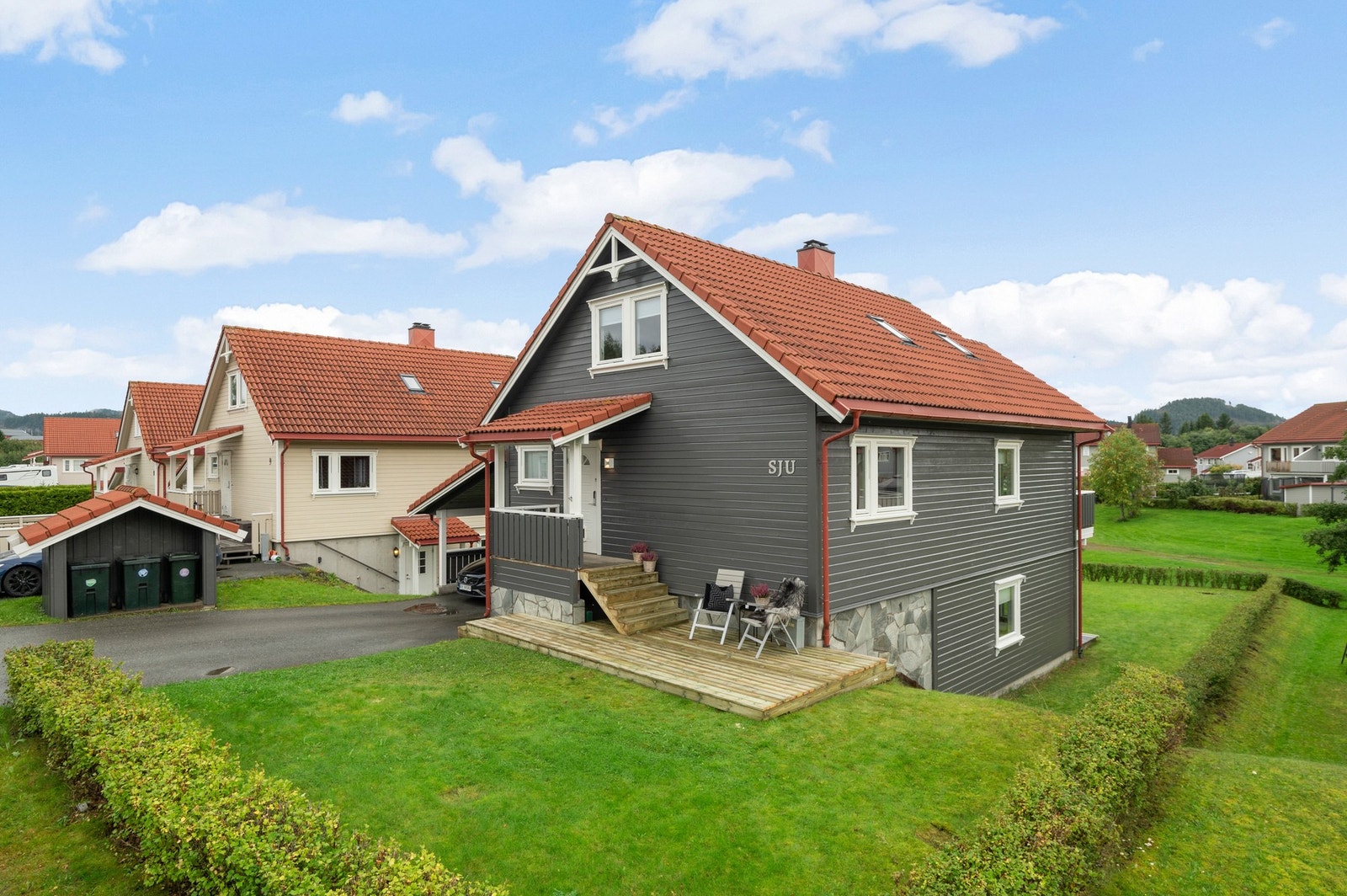 Solrik terrasse på framsiden av huset. Store deler av fasaden er nymalt. Galleribilde