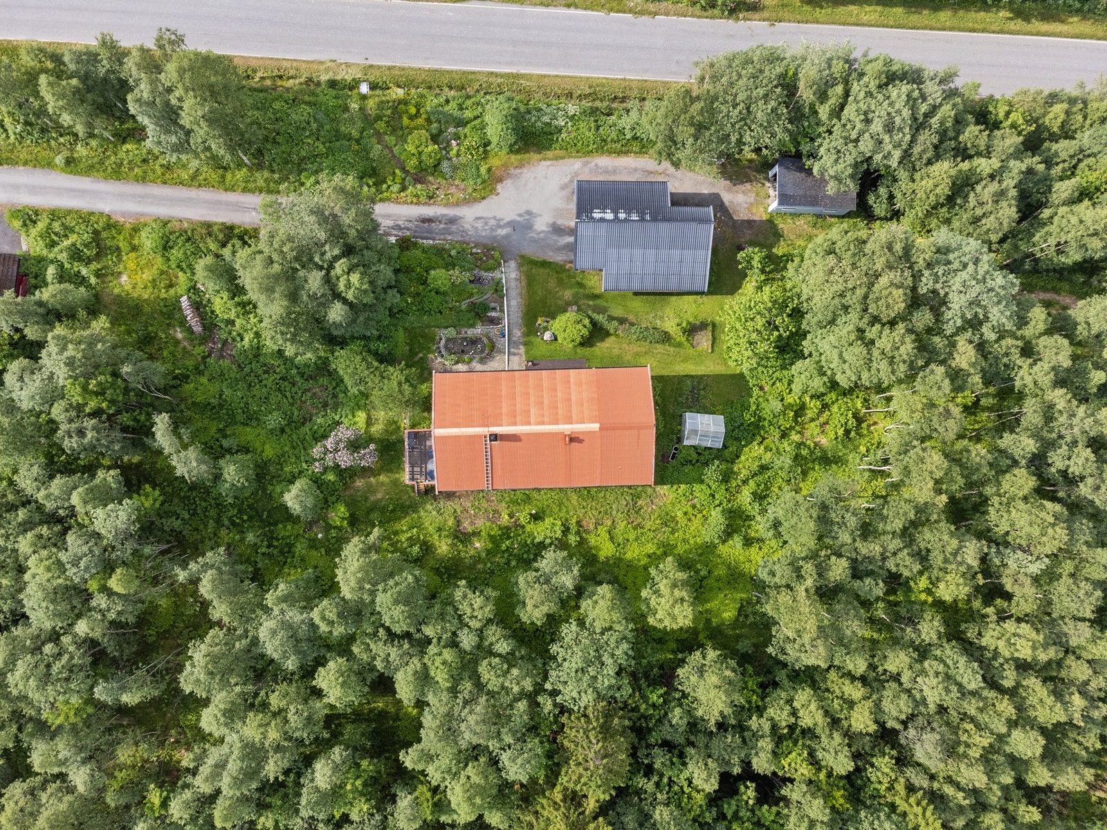 Eiendommen har eiet tomt på totalt 1166,4m² fordelt på to bruksnummer. Traktorgarasjen til høyre i bildet står på en egen tomt og medfølger i handelen. Galleribilde