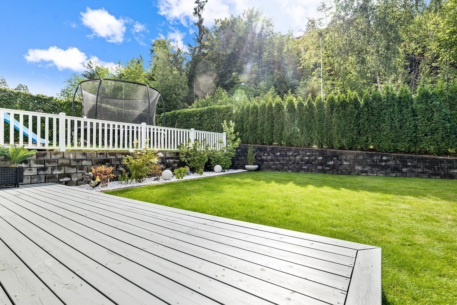 Hagen er pent opparbeidet med plen og bed Galleribilde