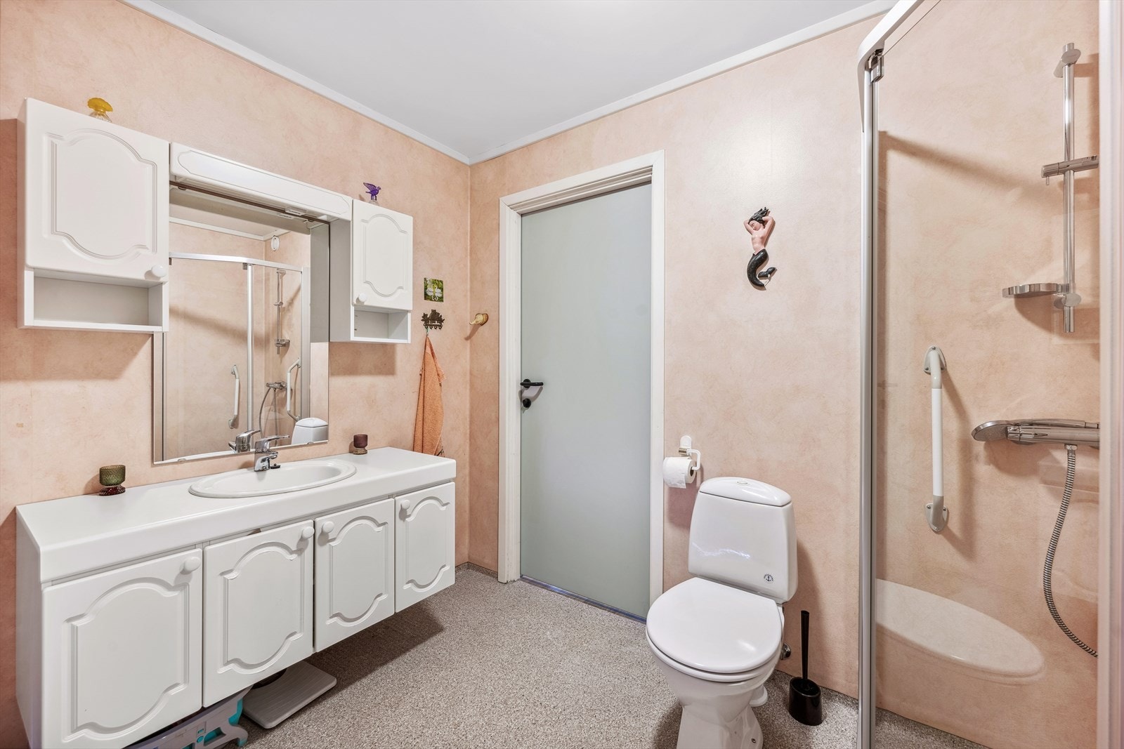 Romslig baderom med adkomst fra entré og soverommet. Badet er gjennomført med belegg på gulv og vegger med våtromstapet/belegg. Galleribilde