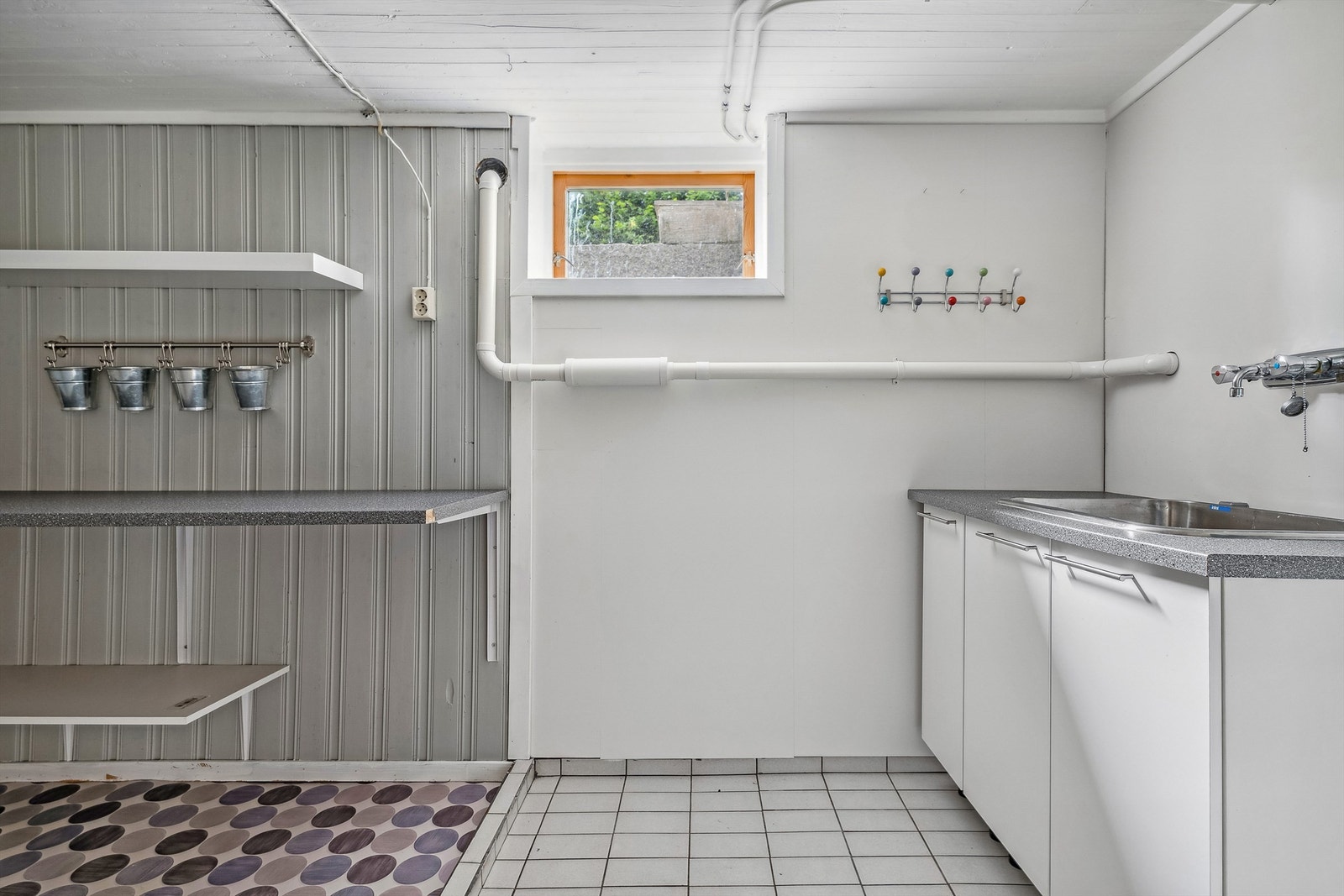 Innredet vaskerom med utslagsvask og opplegg for vaskemaskin Galleribilde
