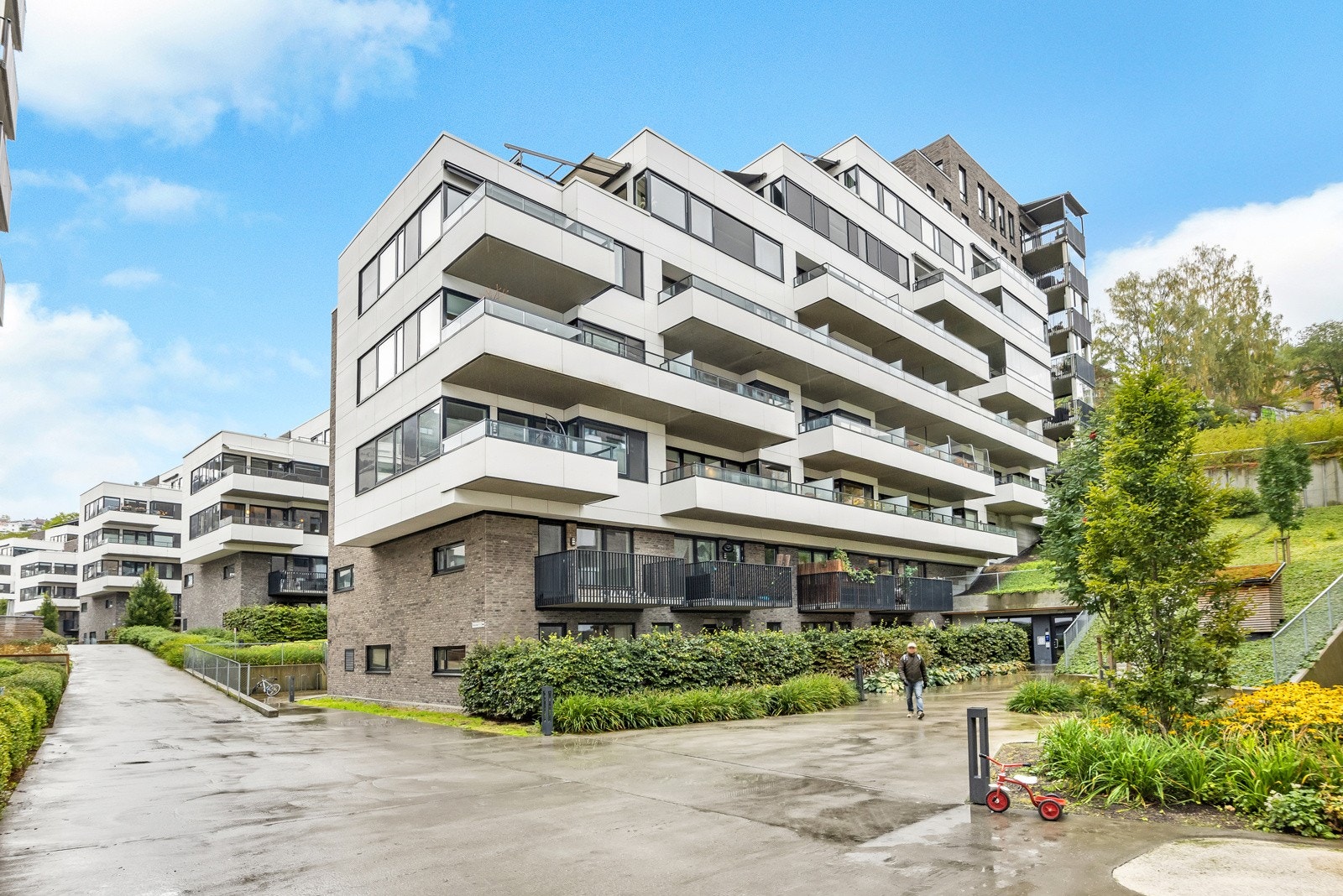 Fellesarealene er pent opparbeidet med plen, prydbusker, sittegrupper, trær, hellelagte gangstier, lekeplass m.m. Galleribilde