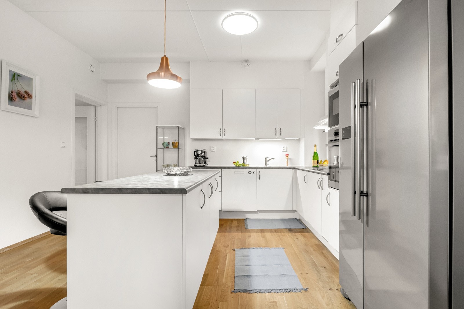 Stilren og moderne innredning med lyse, slette fronter og laminat benkeplate. Galleribilde