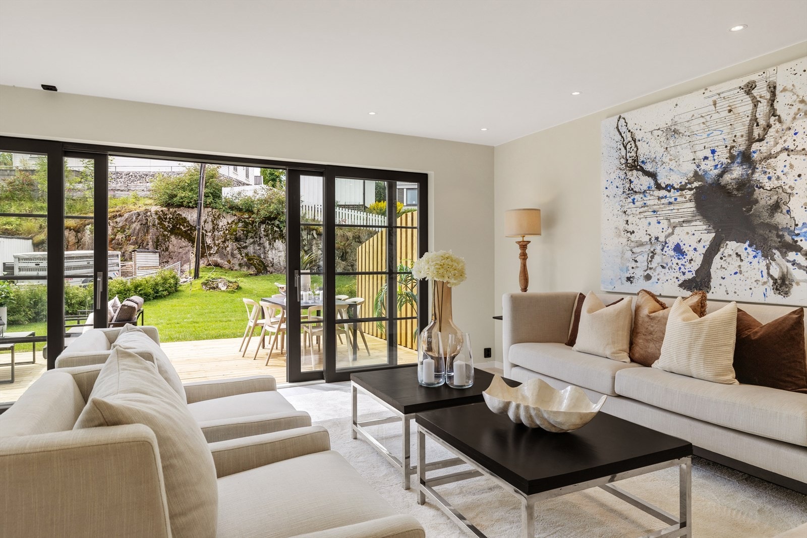 Doble skyvedører leder rett ut til solrik terrasse og grønn hage Galleribilde