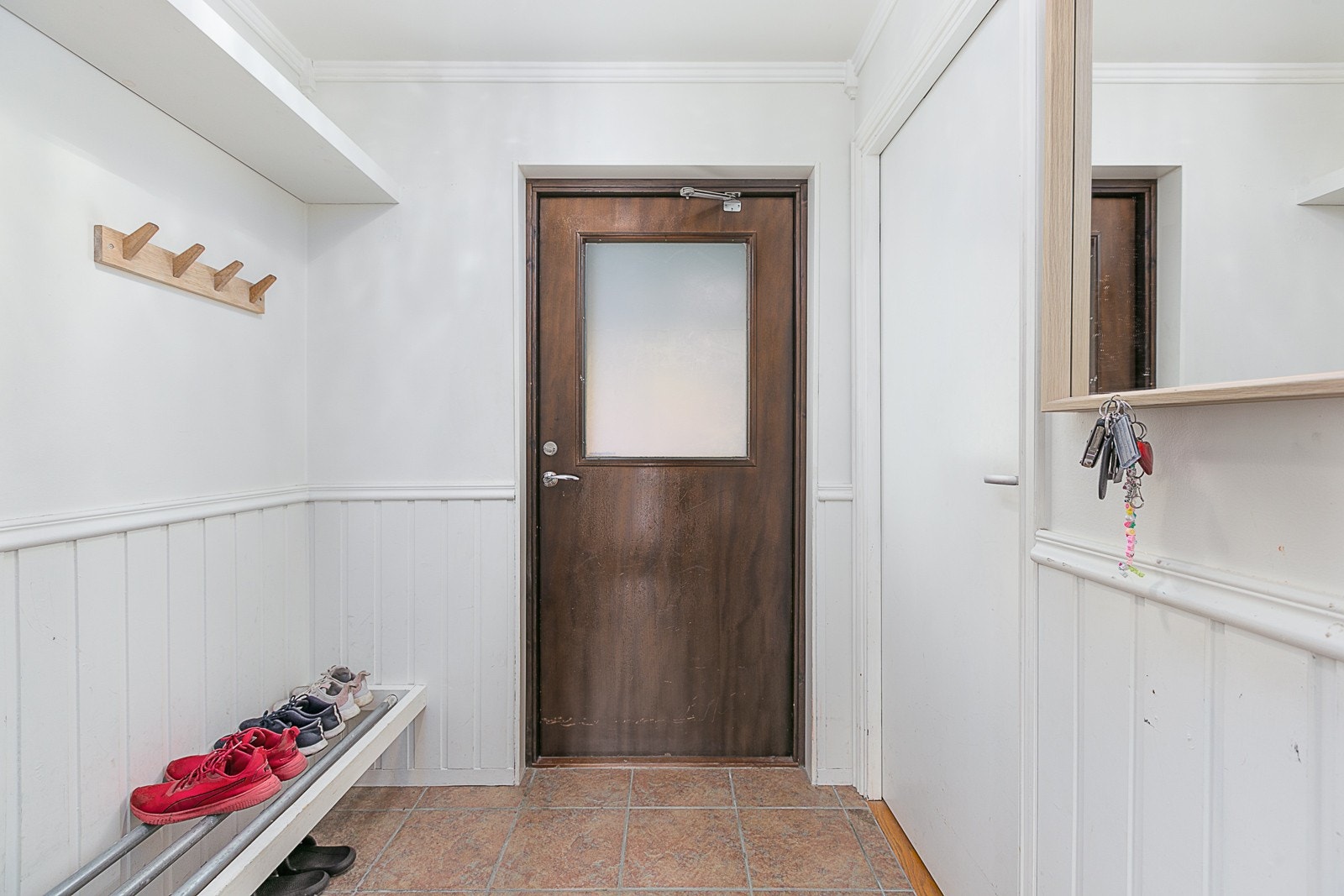 Entrè med plass til å henge fra seg yttertøy, dør til høyre fører inn til bod. Galleribilde