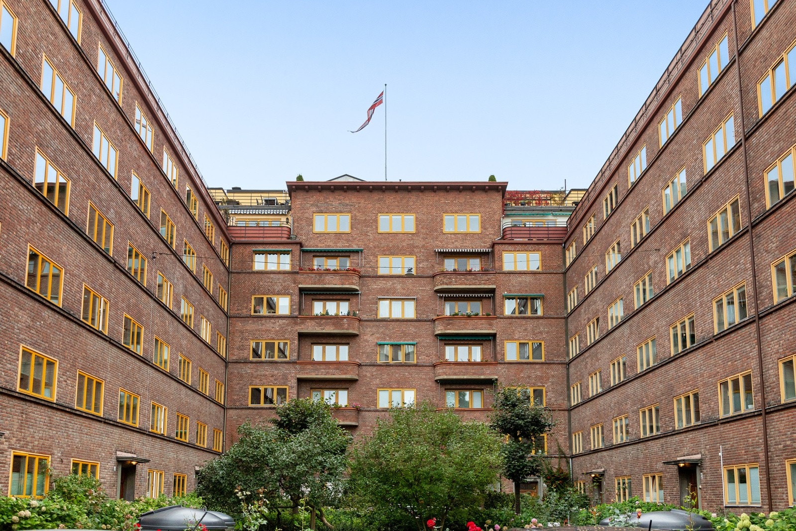 Hyggelig fellesareal med beplantning, krakker og sittegrupper til felles bruk. Galleribilde