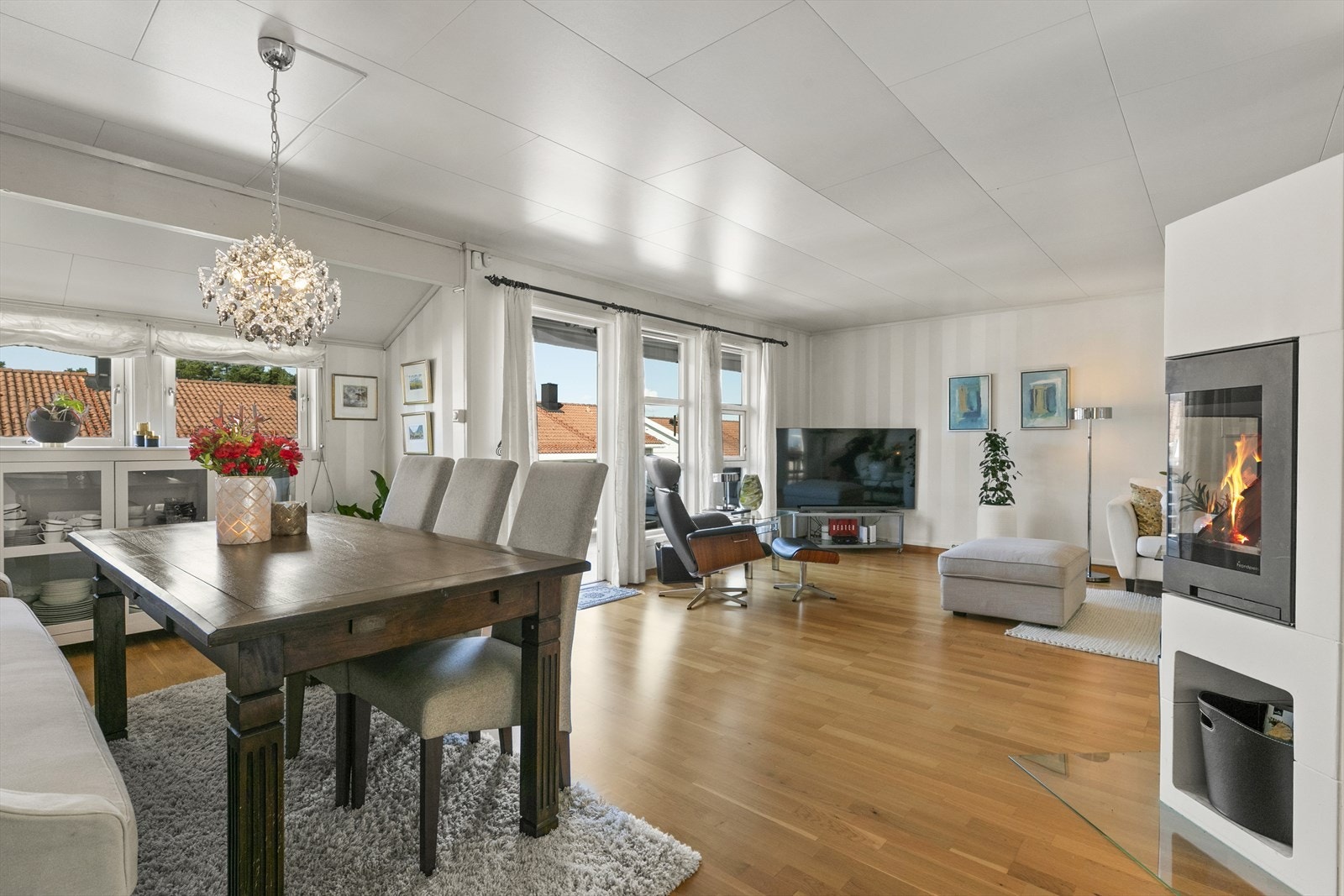 Store vindusflater sørger for å gi stuen rikelig med naturlig dagslys. Galleribilde