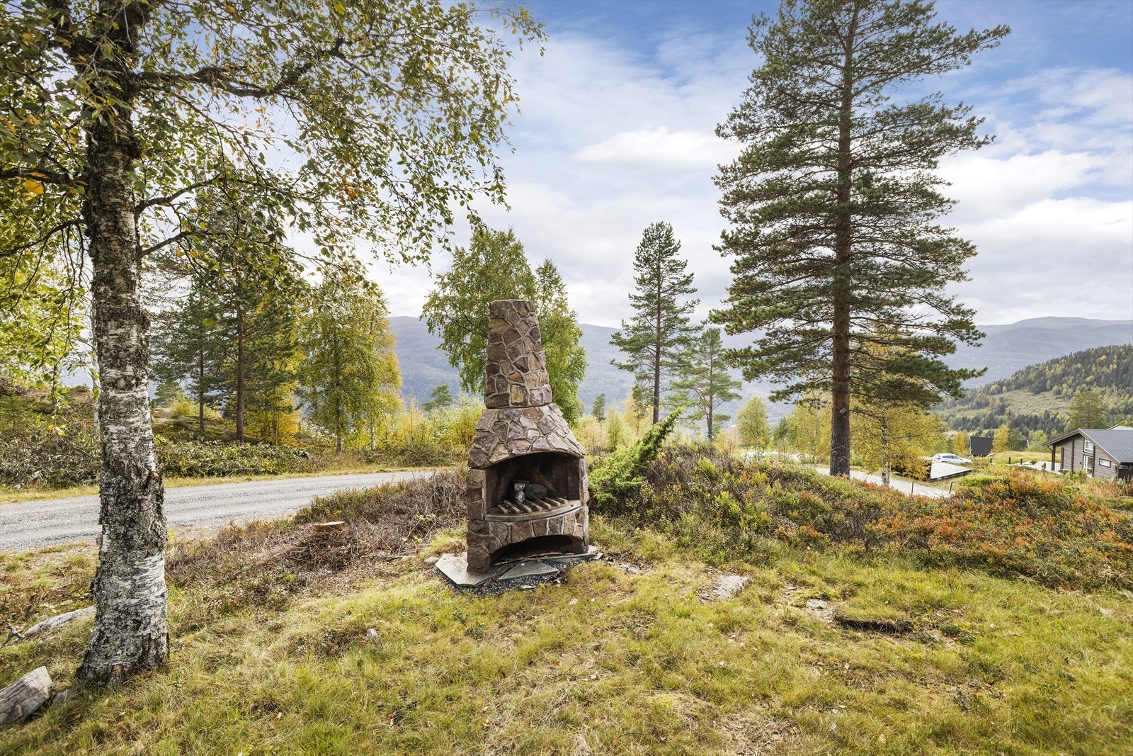 Hytta har også en hyggelig utepeis, og romslig tomt med naturlig vegetasjon. Galleribilde