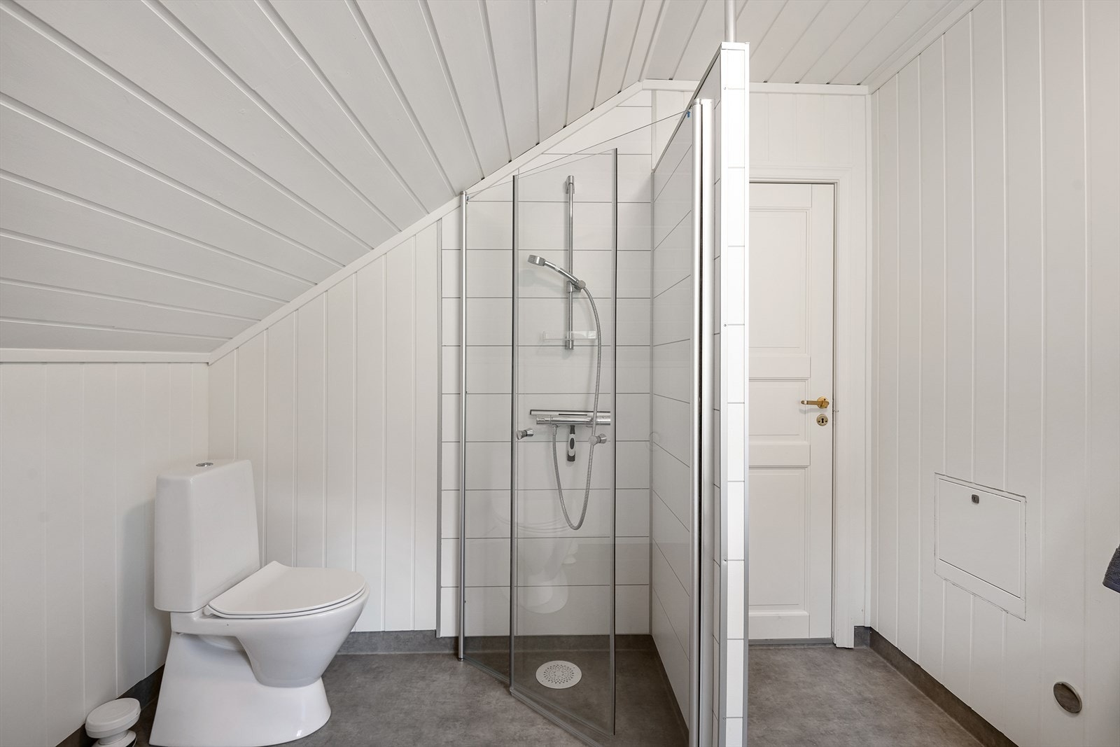 Badet er innredet med dusjhjørne, toalett og baderomsinnredning med heldekkende servant. Galleribilde