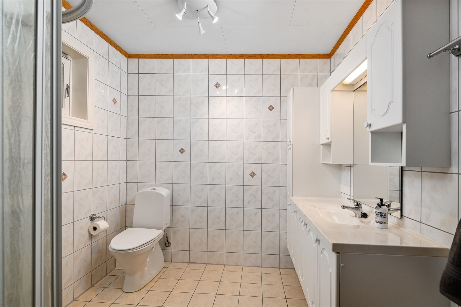 Flislagt bad med wc, servant og dusjhjørne. Galleribilde