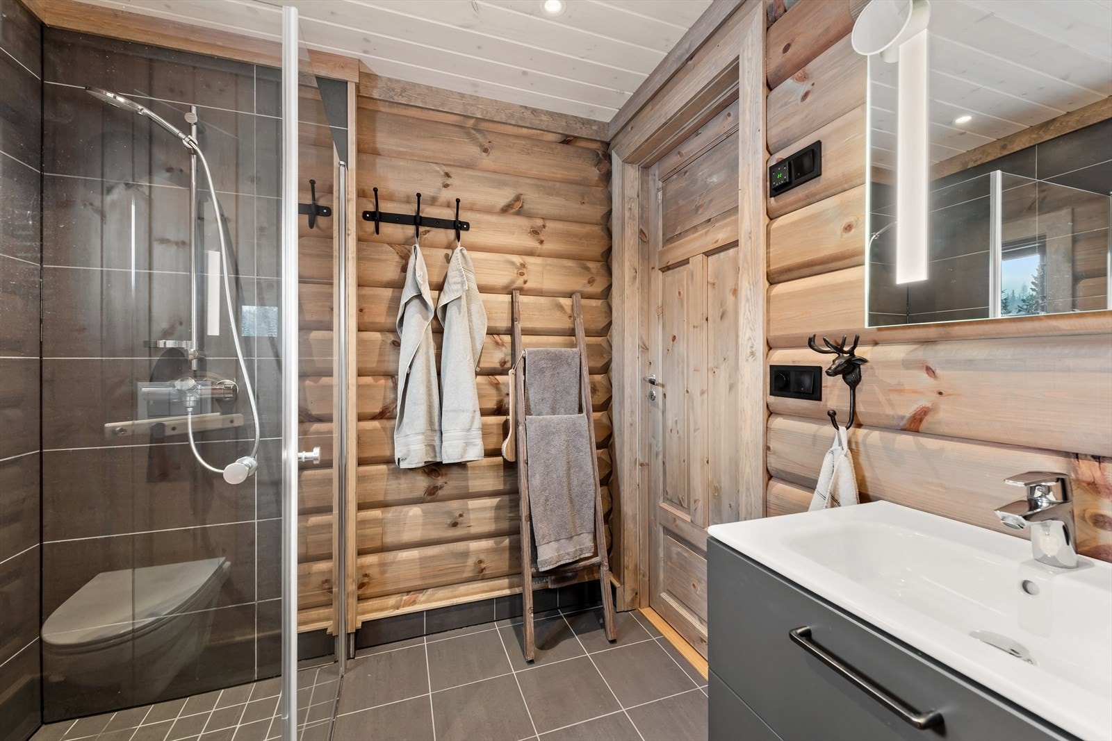 Delikat bad med dusjhjørne, baderomsinnredning, vegghengt klosett og badstue. Galleribilde