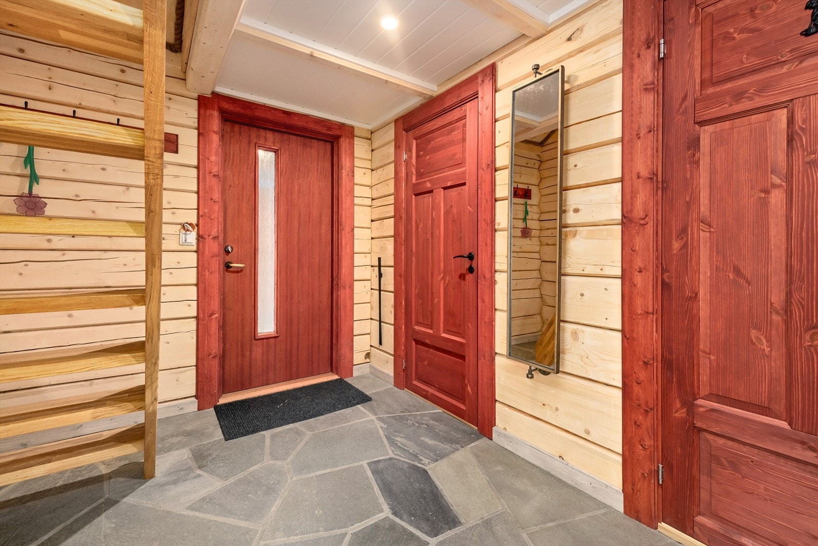 Velkommen inn. Stor hall med skiferstein på gulvet med vannbåren varme under. Galleribilde
