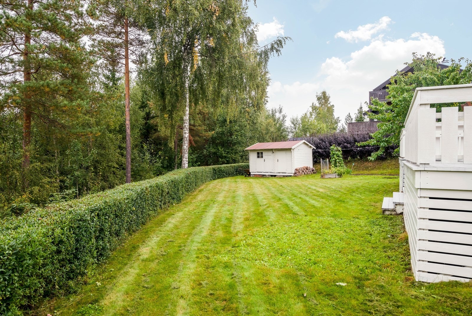 I hjørnet av eiendommen er det plassert en praktisk redskapsbod med oppbevaringsplass. Galleribilde