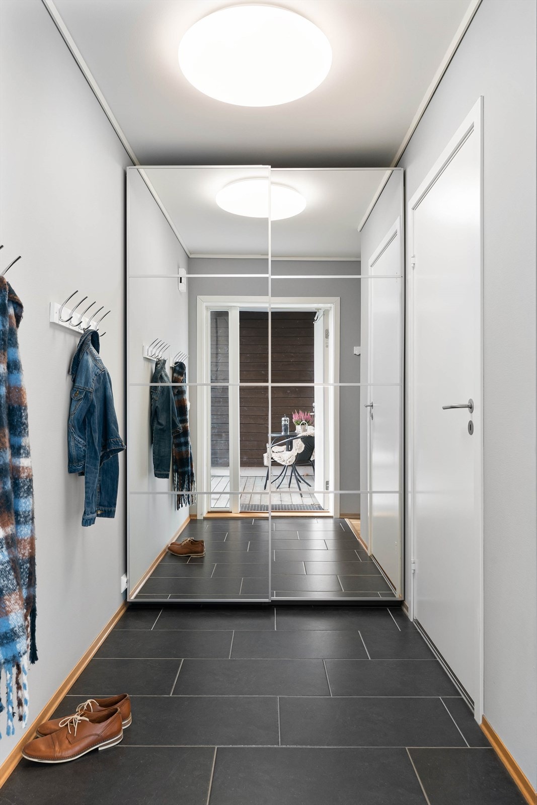 Inngangsparti med praktisk skyvedørsgarderobe Galleribilde