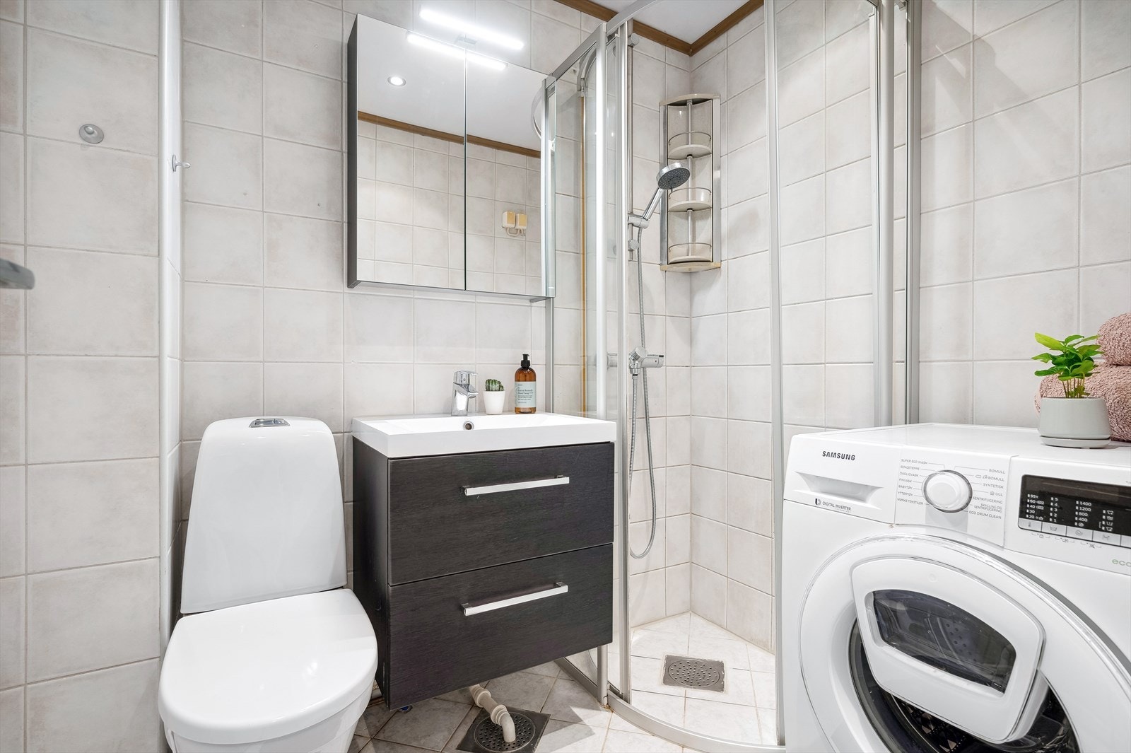 Badet er innredet med toalett, dusjhjørne,
servantinnredning og overskap med speilfronter og belysning. Ny servantinnredning, blandebatteri, overskap og armatur i dusj. Det er opplegg for vaskemaskin. Galleribilde