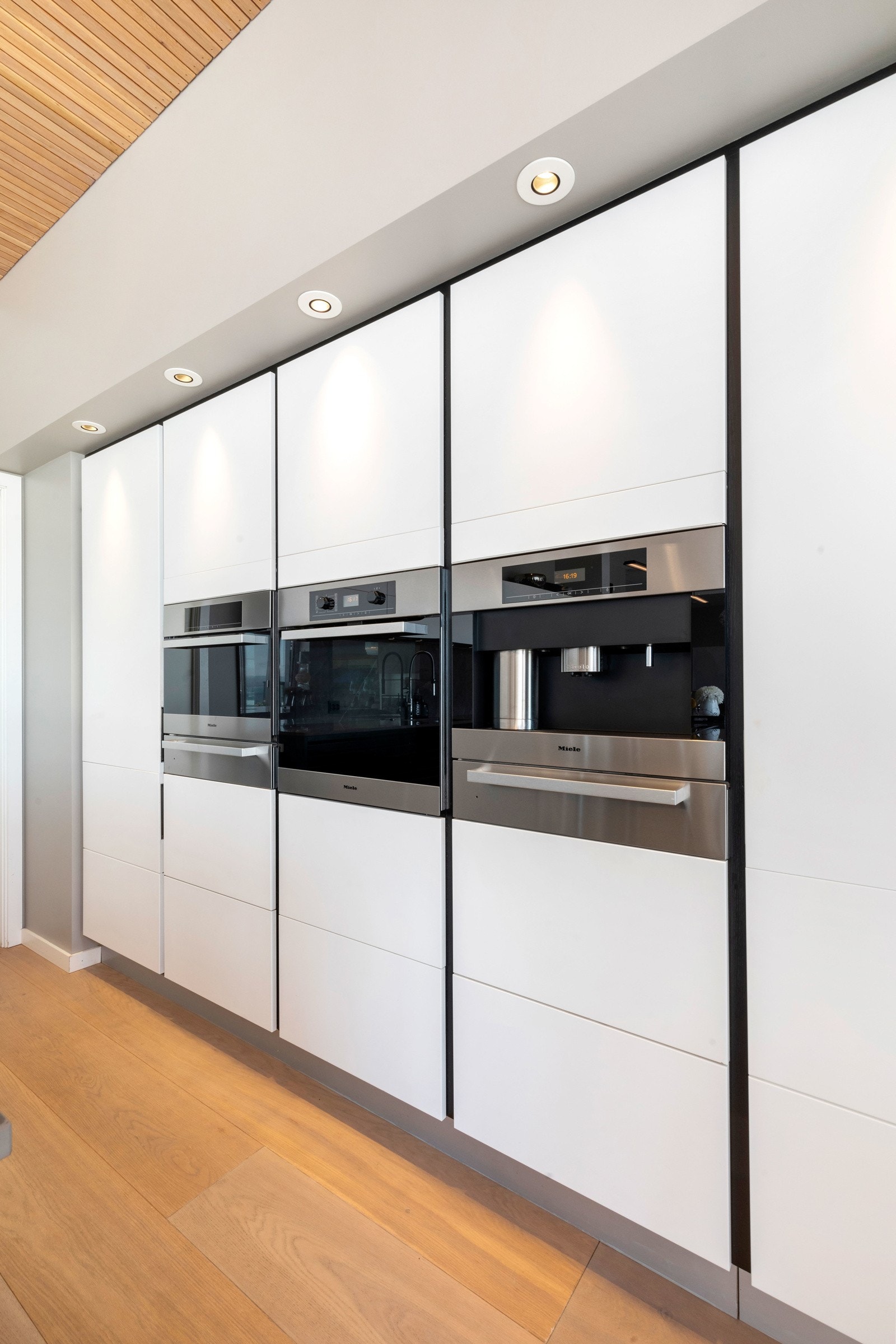 Integrerte hvitevarer som kjøleskap, komfyr, oppvaskmaskin, kaffemaskin og vinskap Galleribilde