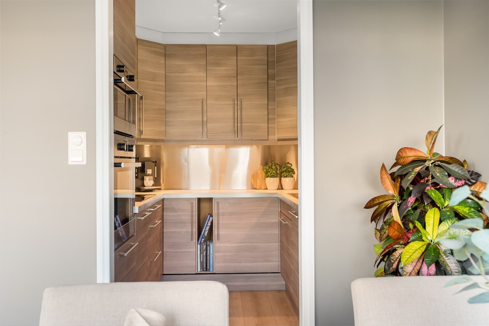 Flott kjøkken med slette fronter og intergrert induksjonsplatetopp, stekeovn, oppvaskmaskin, kjøl- og frys. Galleribilde