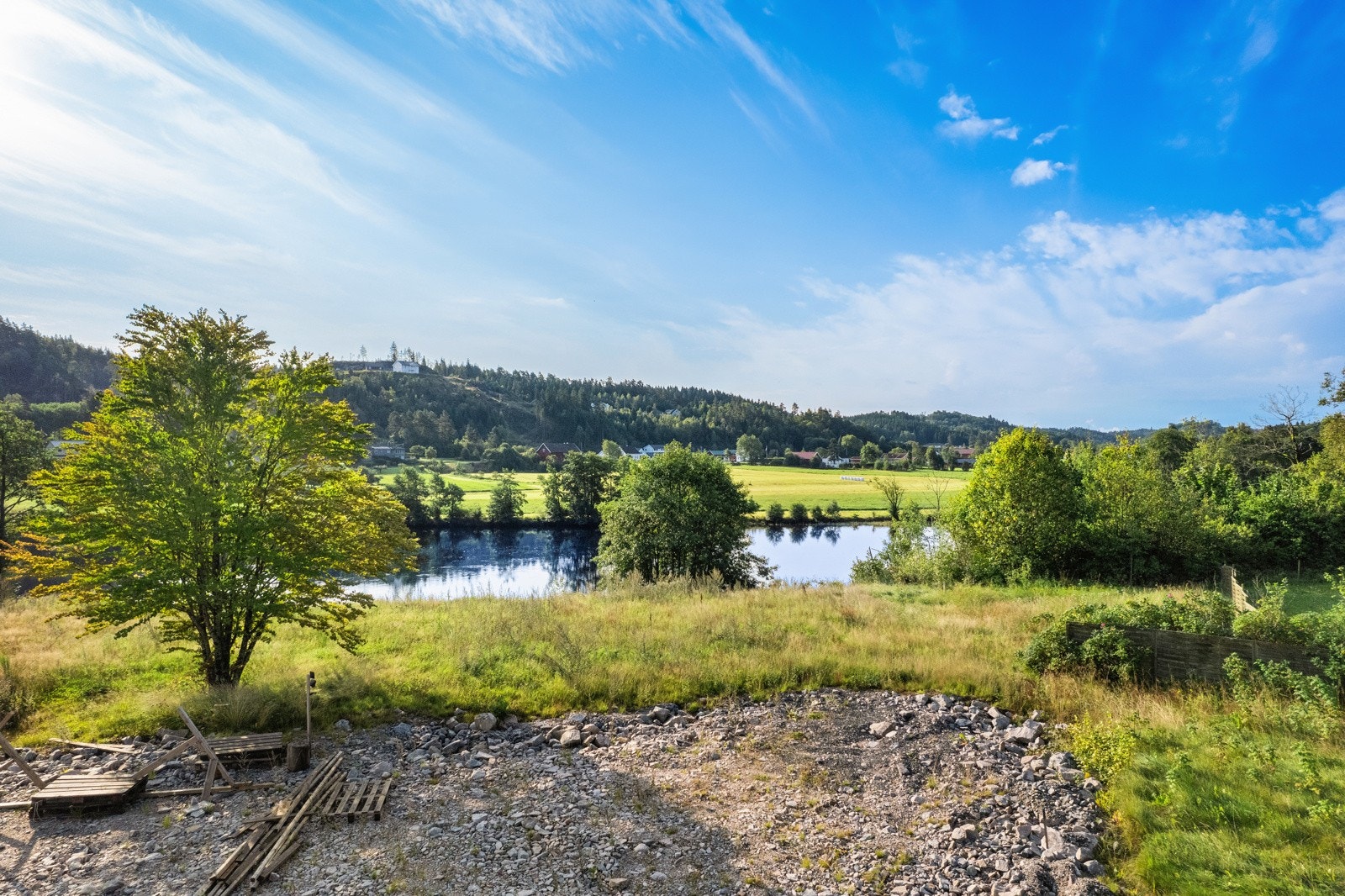 Det er nydelig utsikt mot Mandalselva og rett til bru av stort plenområde frem til helningen. Galleribilde