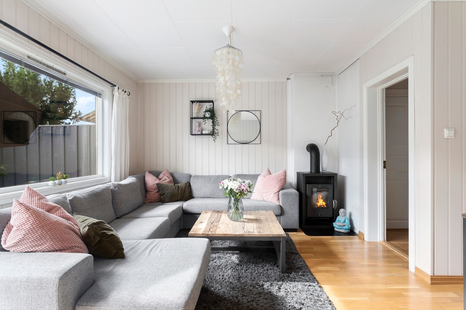 Stuen har stort vindu mot hagen og peisovn som varmer godt på kalde dager. Galleribilde