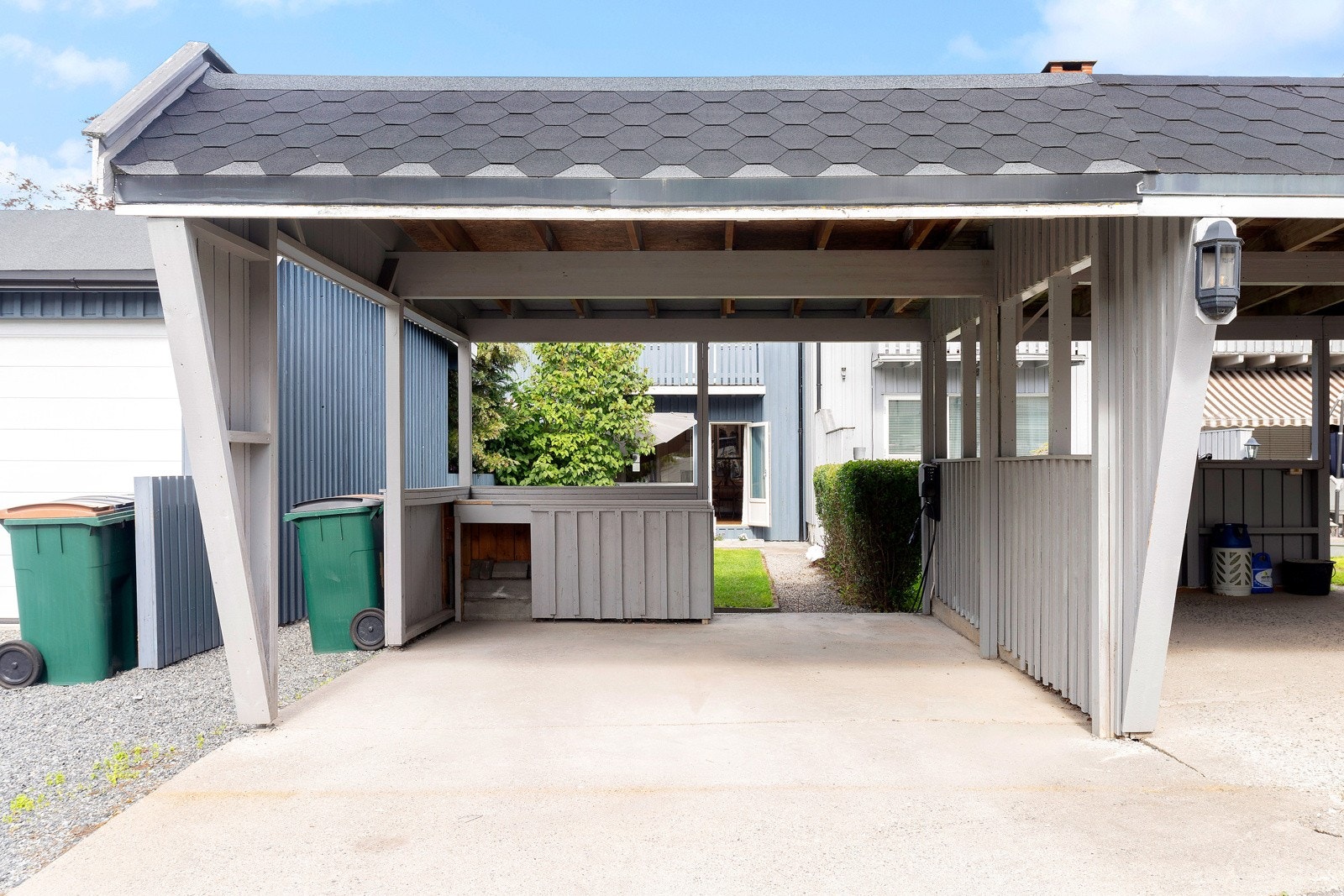 Bilen får plass i en romslig carport. Her er det satt opp ladepunkt til elbil. Galleribilde