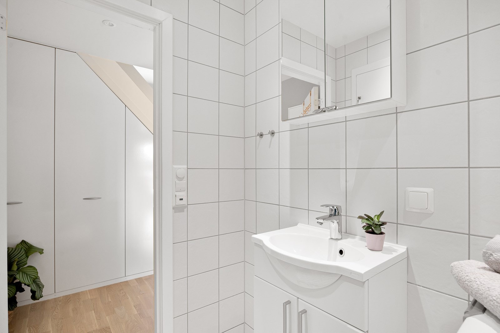 Badet er innredet med vegghengt klosett, servant nedfelt i innredning, speil m/lys og dusjhjørne med svingbare glassdører. Det er opplegg for vaskemaskin. Galleribilde