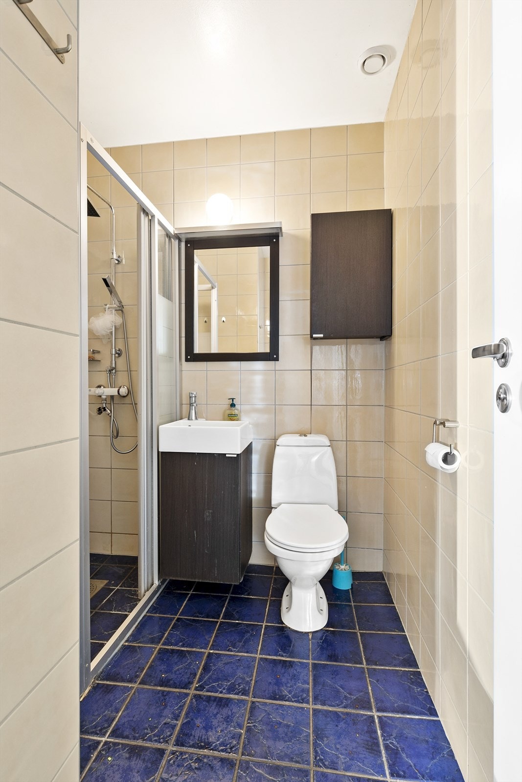 Flislagt bad med dusjsone og opplegg for vaskemaskin. Galleribilde