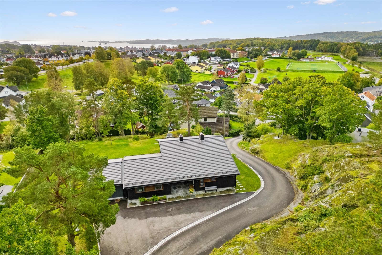 Asfaltert gårdsplass og parkering i tilbygd garasje. Galleribilde