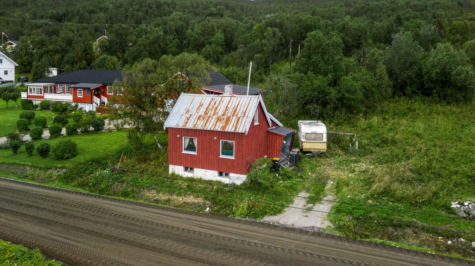 Enebolig med naust og strandlinje sentralt på Hansnes.
