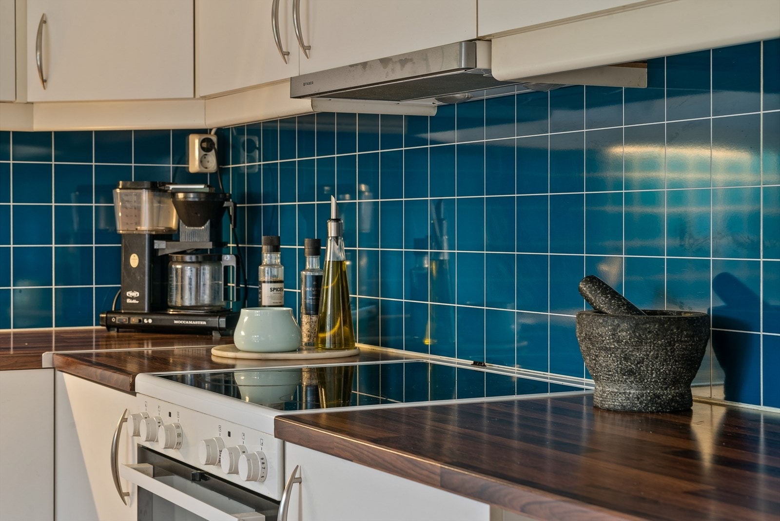 Praktisk Kitchen board med flisemønster på vegger mellom benkeplater og overskap for ekstra beskyttelse. Galleribilde