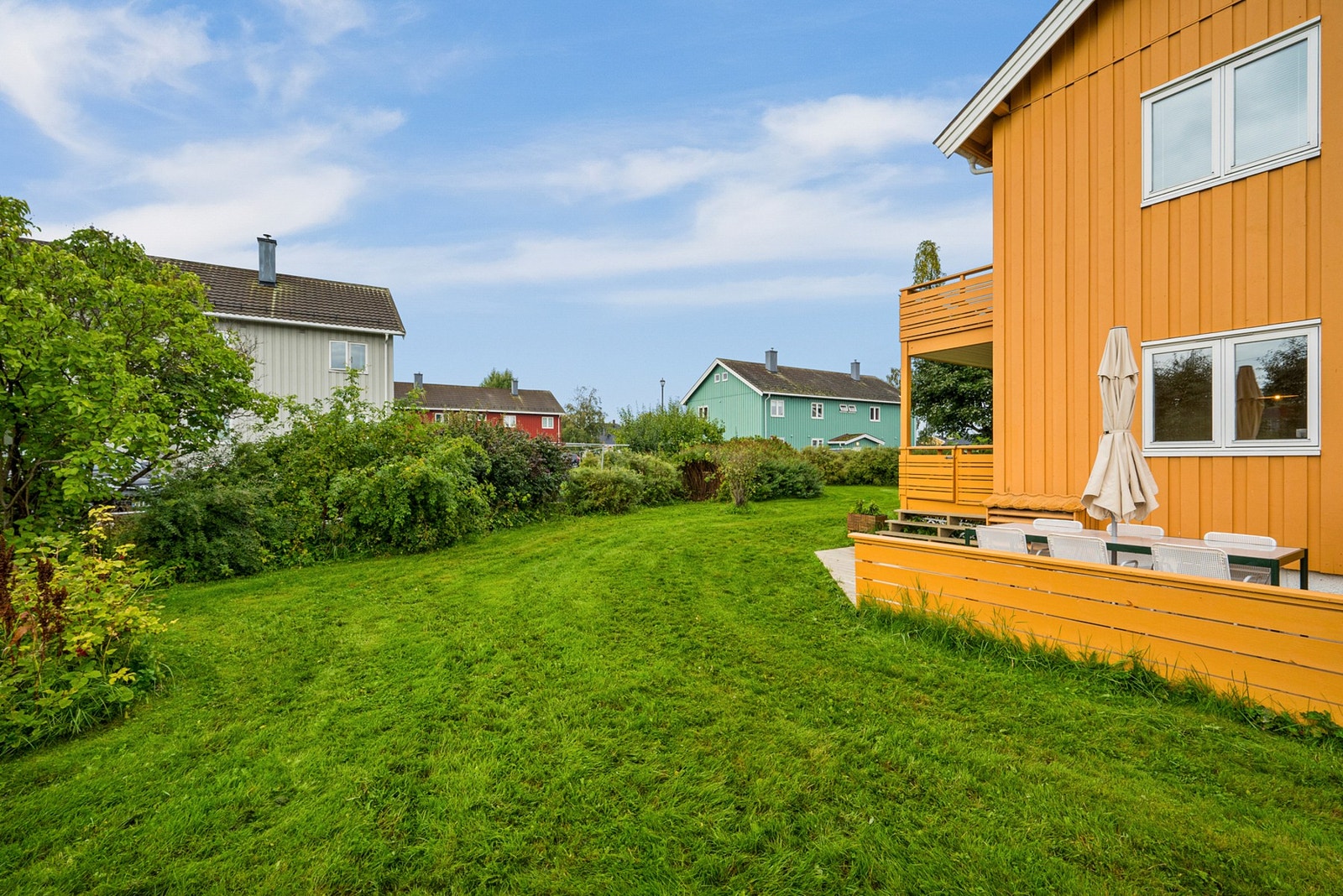 Dette er et rolig boomårde med store plenområder, og diverse beplantning mellom husene. Galleribilde