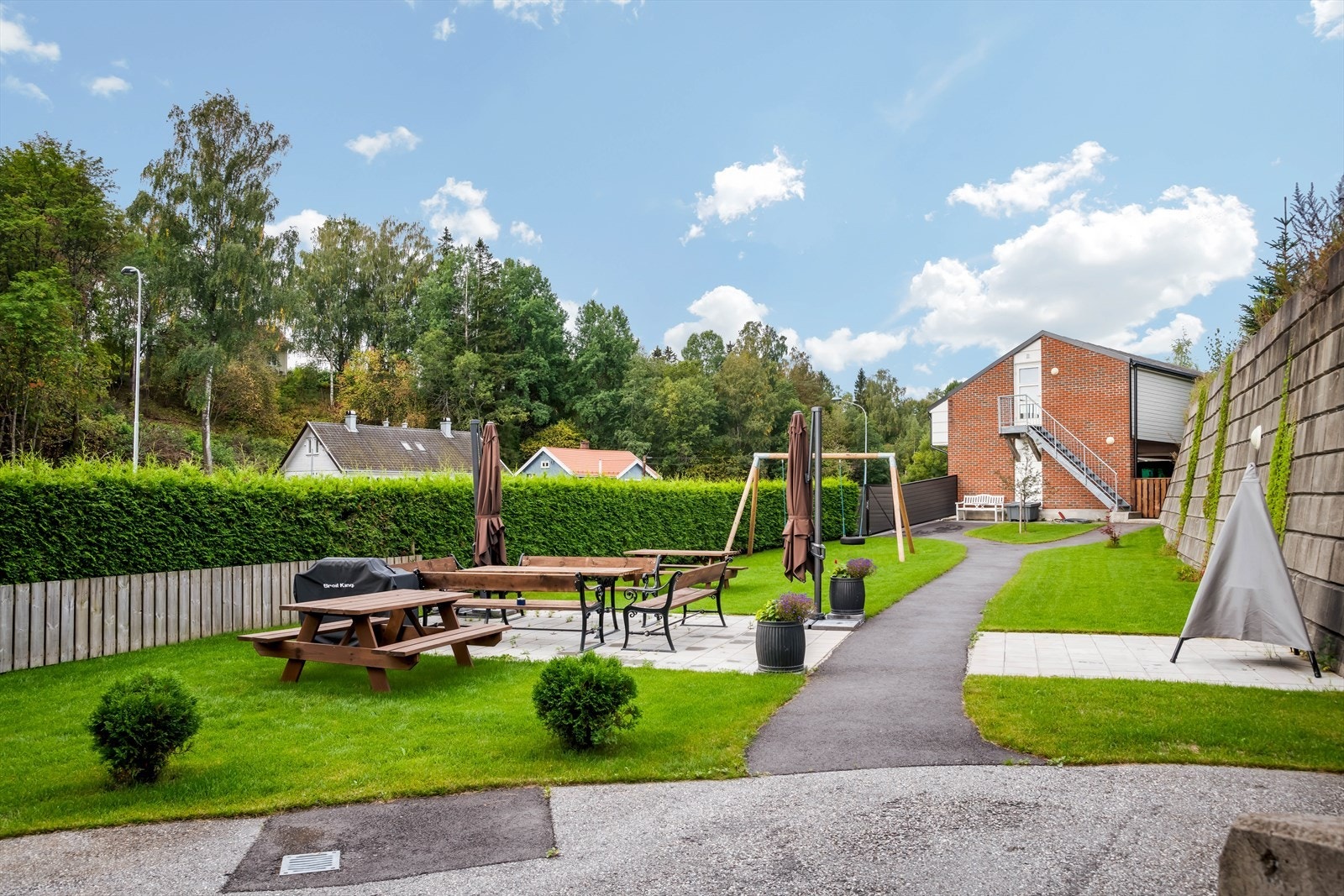 Tomten er opparbeidet med felles parkering og internveier, samt flotte utearealer med plen, beplantning, lekeapparater og sitteplasser. Galleribilde