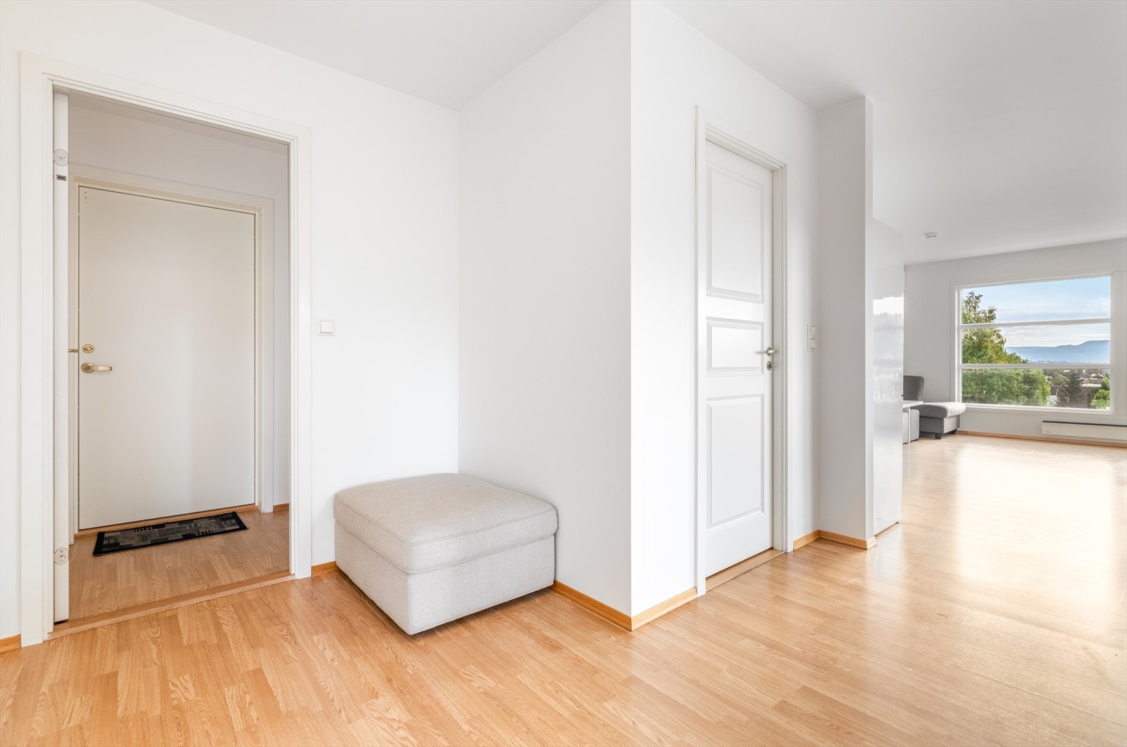 Leiligheten har en hyggelig entré og gang som ønsker velkommen inn. Her er det god plass til å sette fra seg sko og henge fra seg yttertøy. Galleribilde