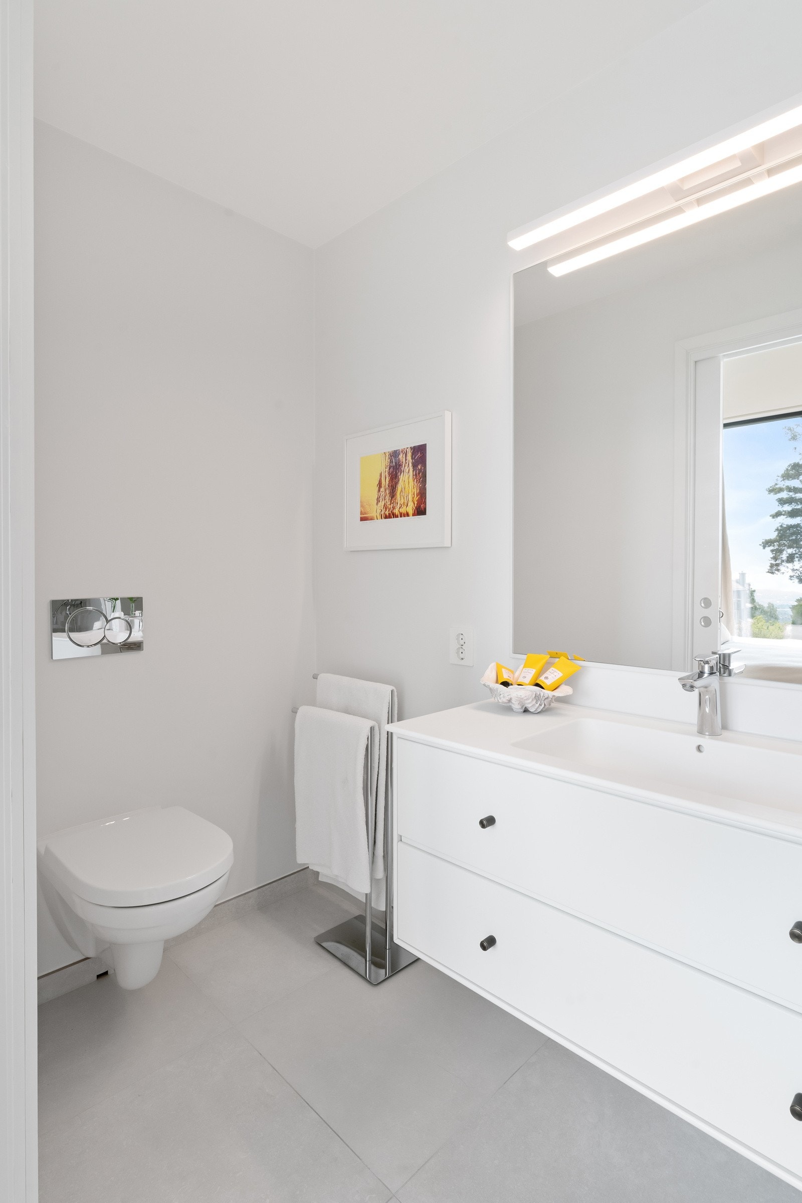 Videre har badet vegghengt toalett og skap fra Montana med to skuffefronter og heldekkende servant i hvit corian. Over servanten er det speil og belysning. Galleribilde