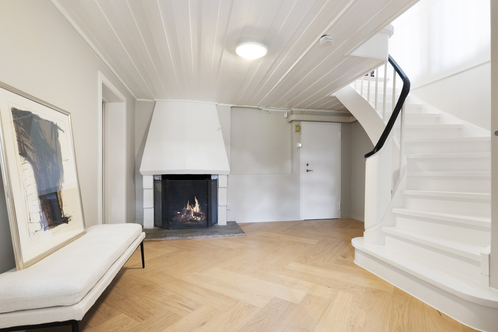 Det første som møter deg når du tar deg ned trappen til underetasjen, er en romslig hall med peis. For øvrig har underetasjen soverom, bad, vaskerom, fyrrom, samt rikelig med bodplass. Galleribilde