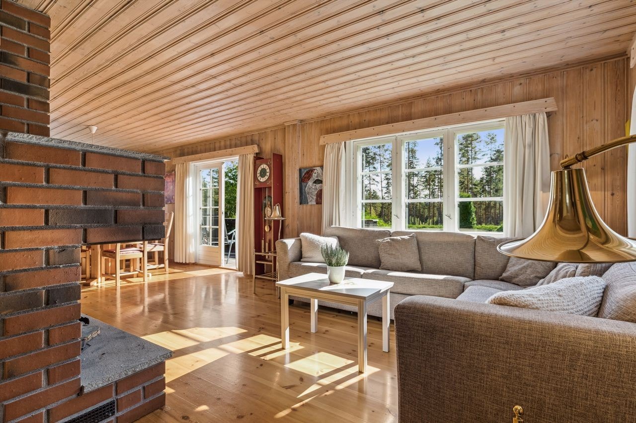 Stuen er lun og trivelig, og har plass til sofahjørne og spisestuemøblement Galleribilde