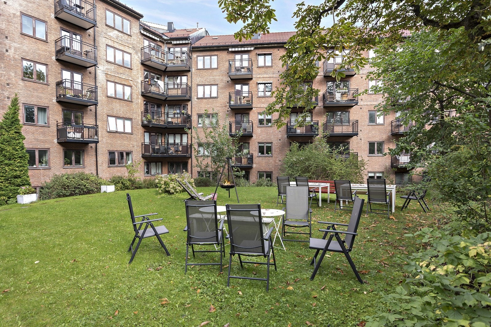 Her er det hyggelige sittegrupper, gressplen og beplantning, og det er godt med sykkelparkering bak lukket hovedport Galleribilde