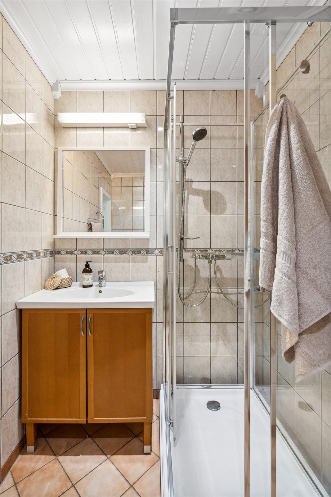 Badet er utstyrt med nyere dusjkabinett, servant med skapinnredning og toalett. Galleribilde