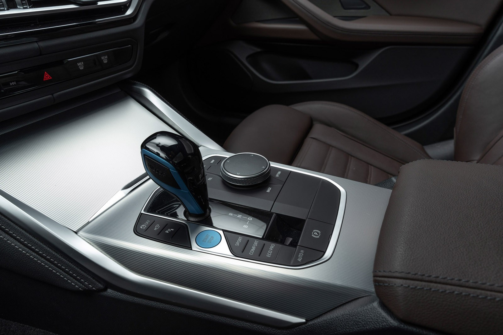 iDrive hjul i midtkonsollen for blant annet styring av BMWCurved Display - Valg av kjøremoduser på bryterpanel i midtkonsollen