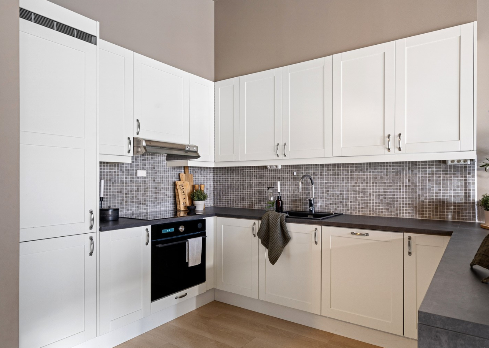 Sigdal kjøkkeninnredning med over- og underskap, hvite møbelplater i fronter, folierte skrog og laminert benkeplate. Galleribilde