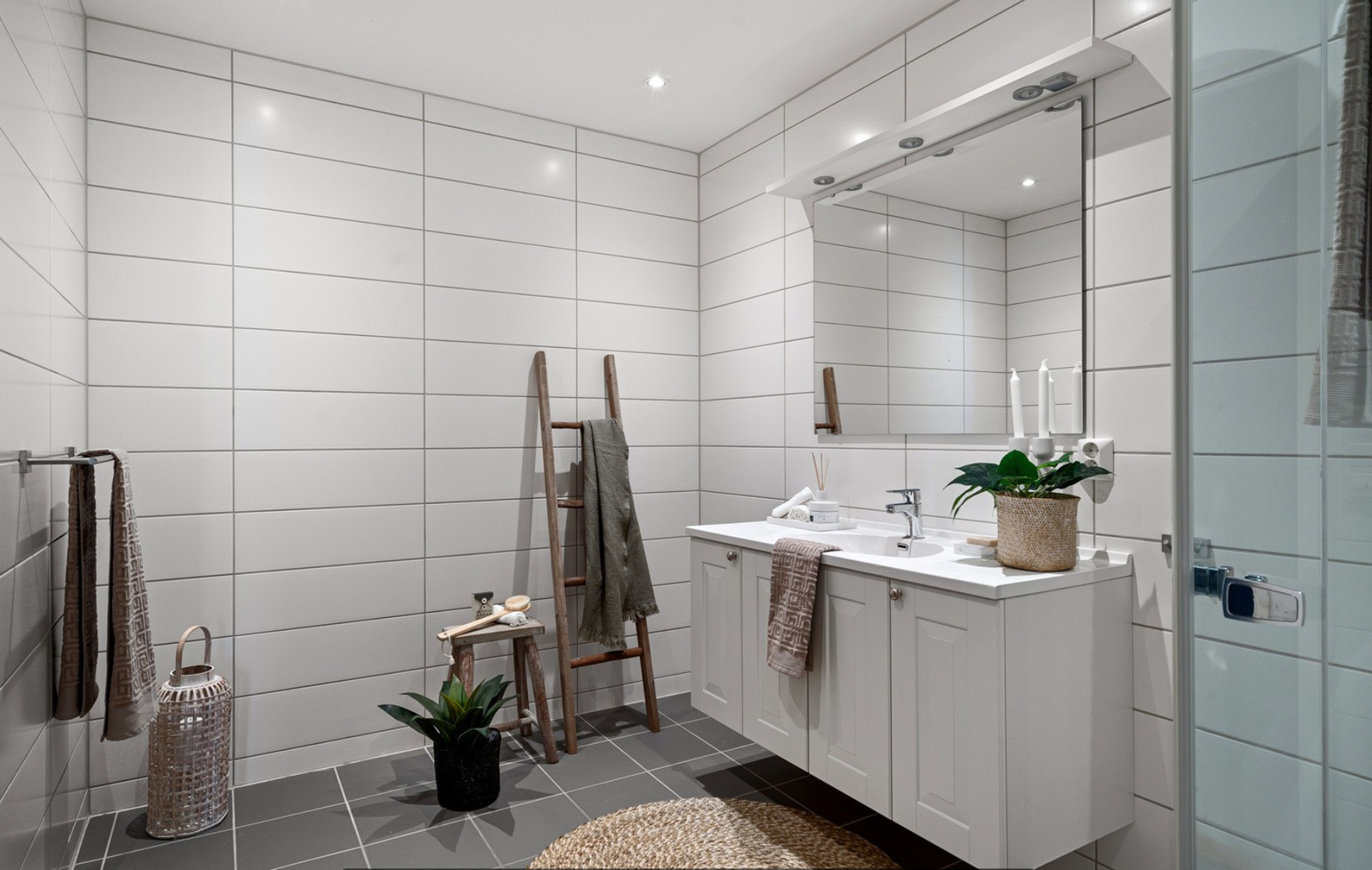 Tidløs innredning med servantplate på underskap, vegghengt håndkleholder og speil. Galleribilde