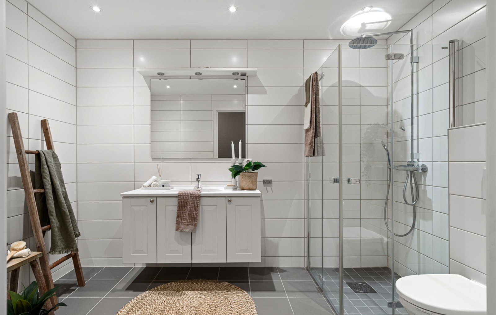 Stilig bad som fremstår som ved byggeår. Flislagte vegger og flislagt gulv med varmekabler. Leilighet har et eget vaskerom. Galleribilde