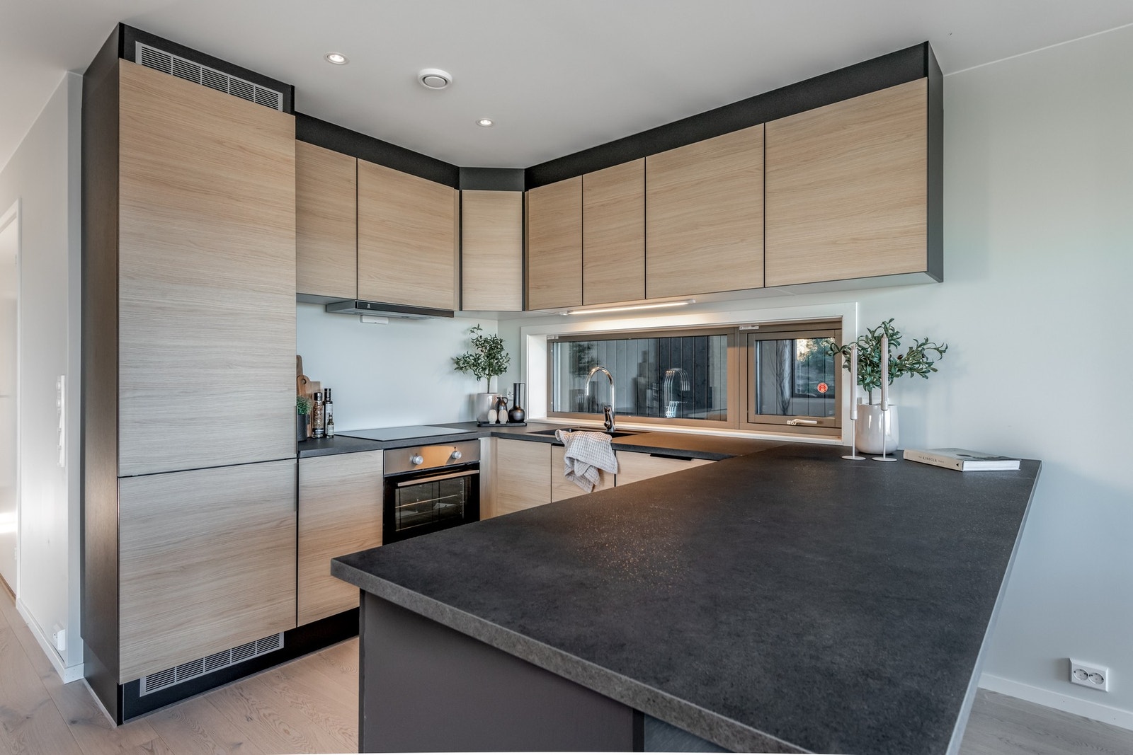 Kjøkken med integrerte hvitevarer og rikelig med benk og skapplass. Galleribilde