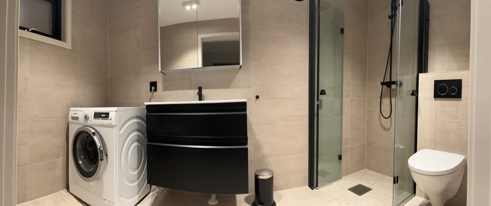 Bad med oppvaskmaskin og grei plass til tørkestativ Galleribilde