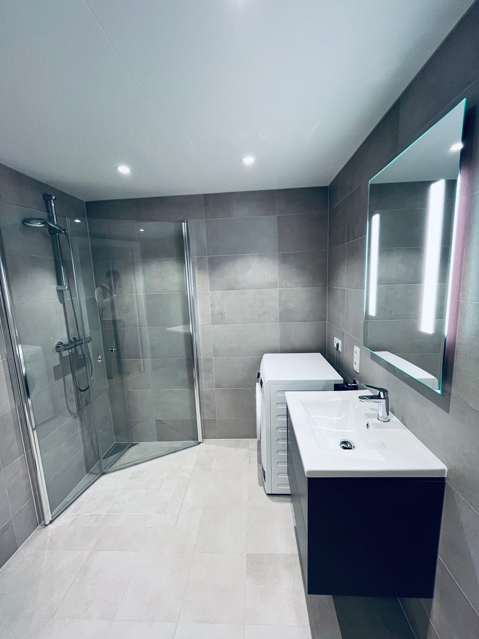 Lekkert bad med dusjhjørne og vaskemaskin Galleribilde